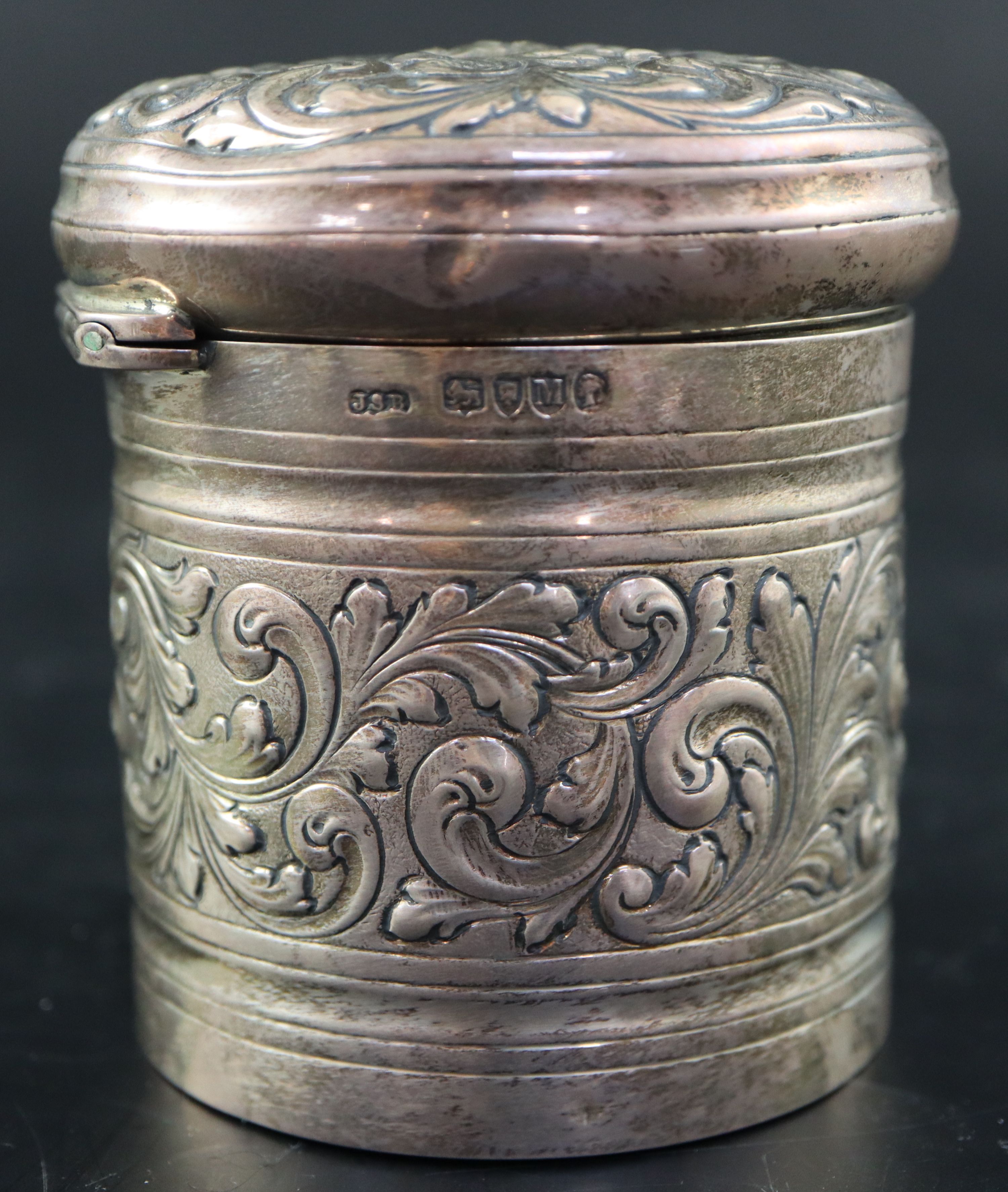 A Victorian embossed silver toilet jar, London, 1887, 93mm, 160 grams and a silver mounted clothes brush.